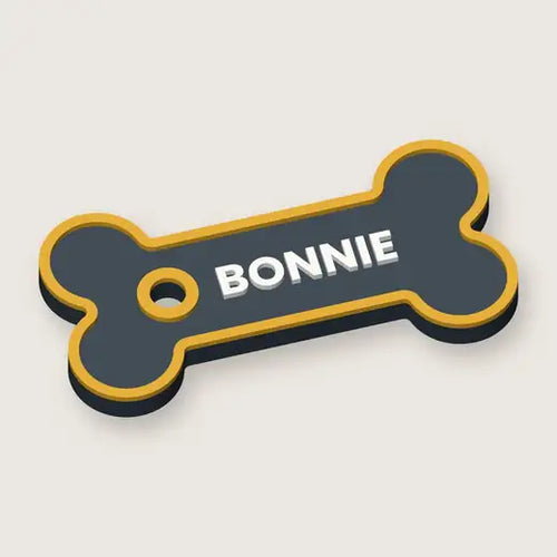 Personalised bone name tag reading BONNIE, slate with gold edge